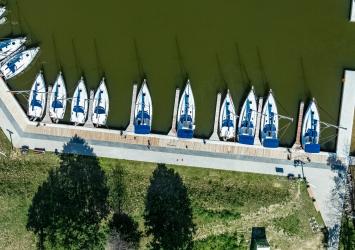 Widok na basen portowy Przystani Nautica z lotu ptaka. Widać nadbrzeże cumownicze oraz łodzie czarterowe