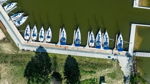 Widok na basen portowy Przystani Nautica z lotu ptaka. Widać nadbrzeże cumownicze oraz łodzie czarterowe